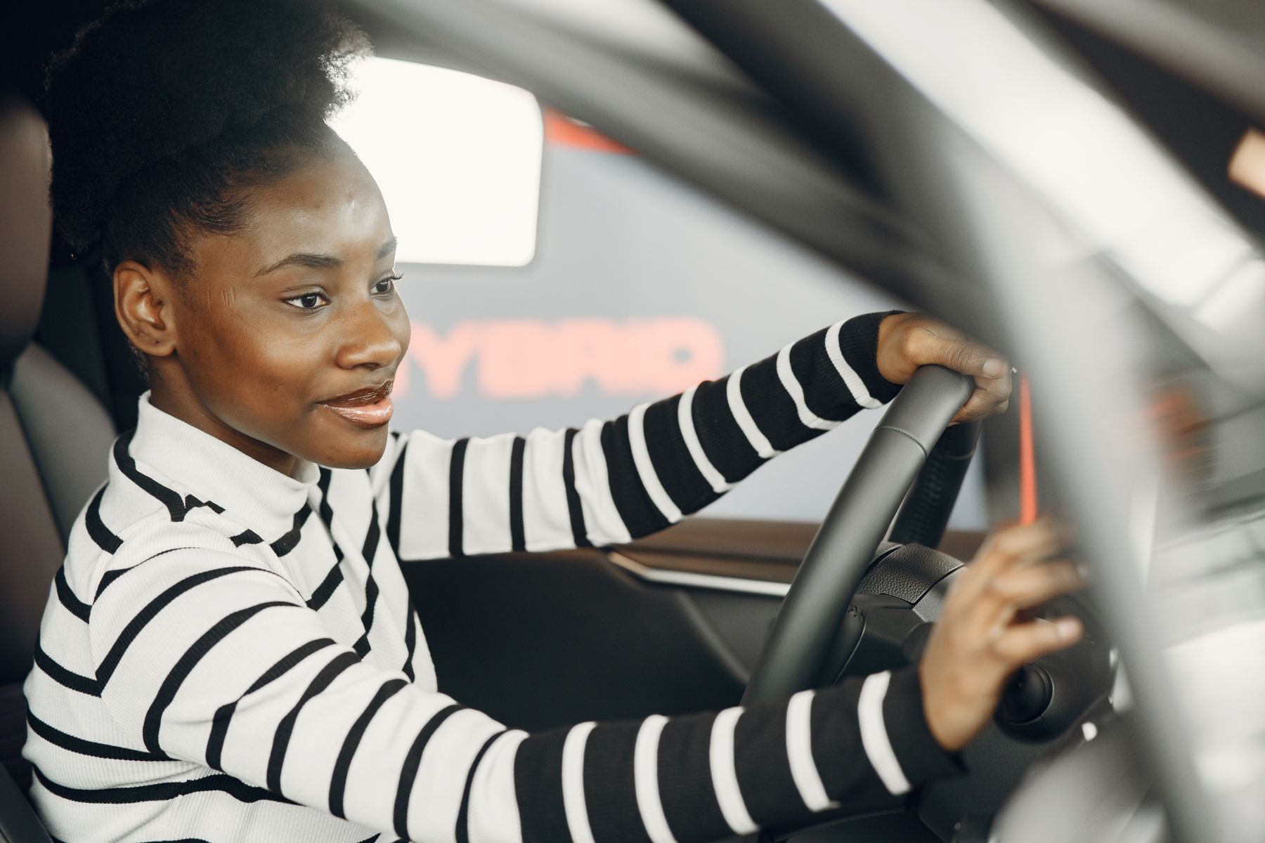 A confident driver checking the controls in her car